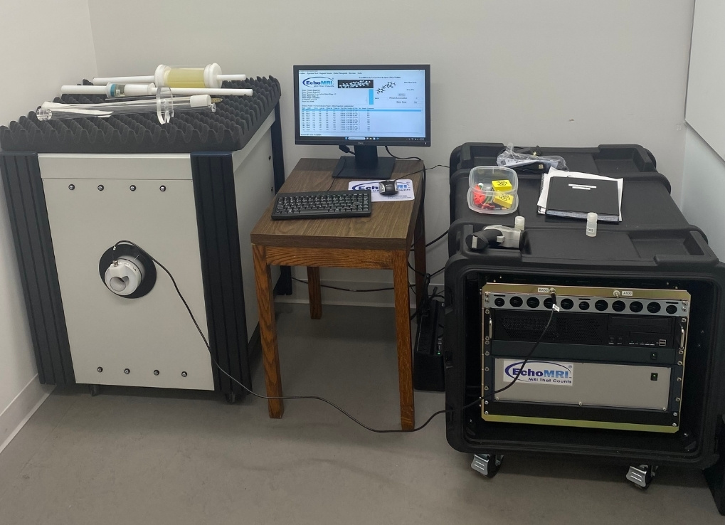A machine setup connected to a desktop computer monitor in the middle. The machines on the left and right are large square cubes.